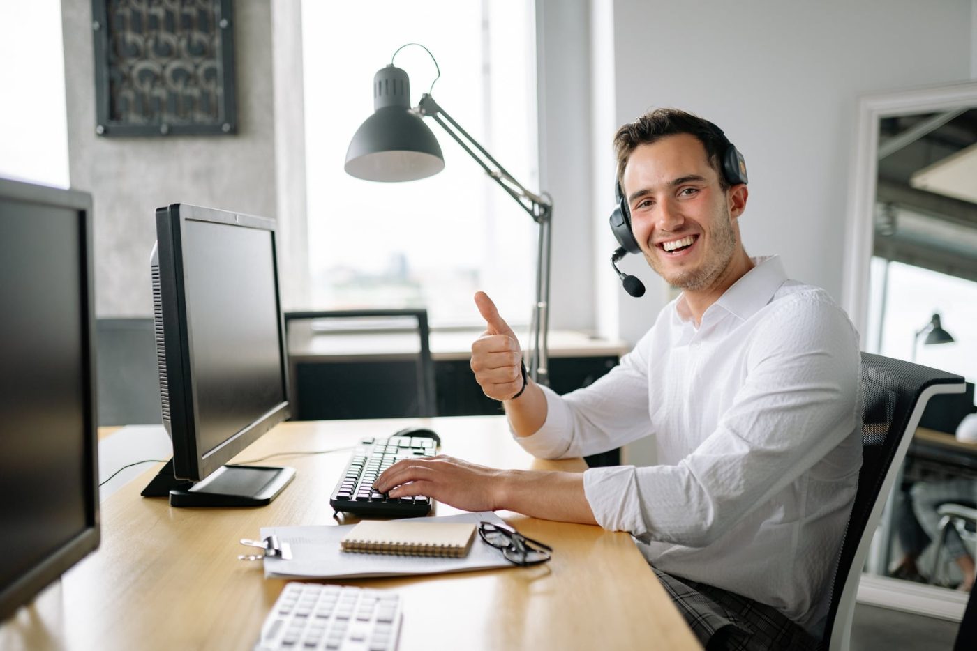 Support specialist with headset working at an operations desk