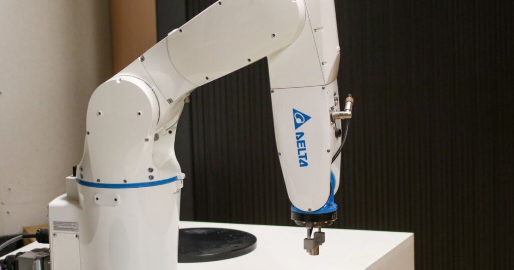 White industrial robotic arm in an automated setup