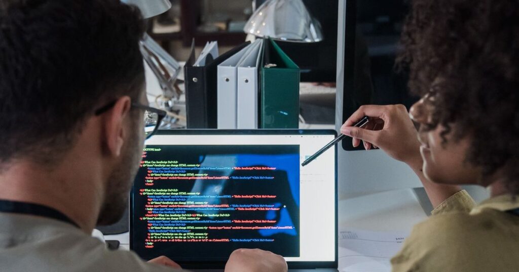 Software developers reviewing code together at a desk