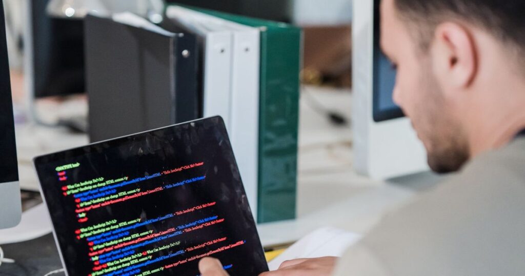 Developer writing code on a laptop